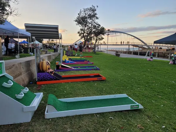 Lucky Shot Mini Golf course set up at the MCG Melbourne with stadium seating visible behind