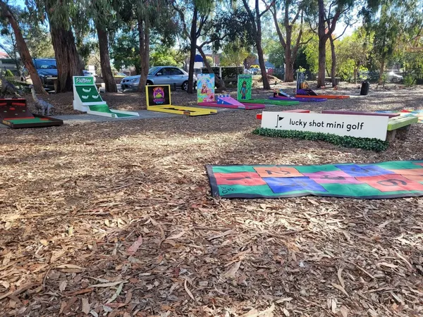 Lucky Shot Mini Golf course laid out under shade trees at a Melbourne park event