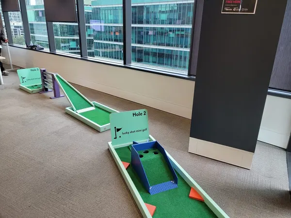 Lucky Shot Mini Golf holes installed between glass-walled meeting rooms in a premium Melbourne office