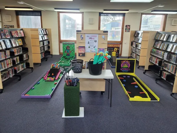 Lucky Shot Mini Golf course weaving between desks and bookshelves in a Melbourne library workspace