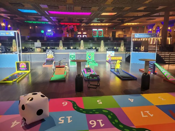 Lucky Shot Mini Golf installation at a neon-lit Melbourne event venue with pink stage lighting