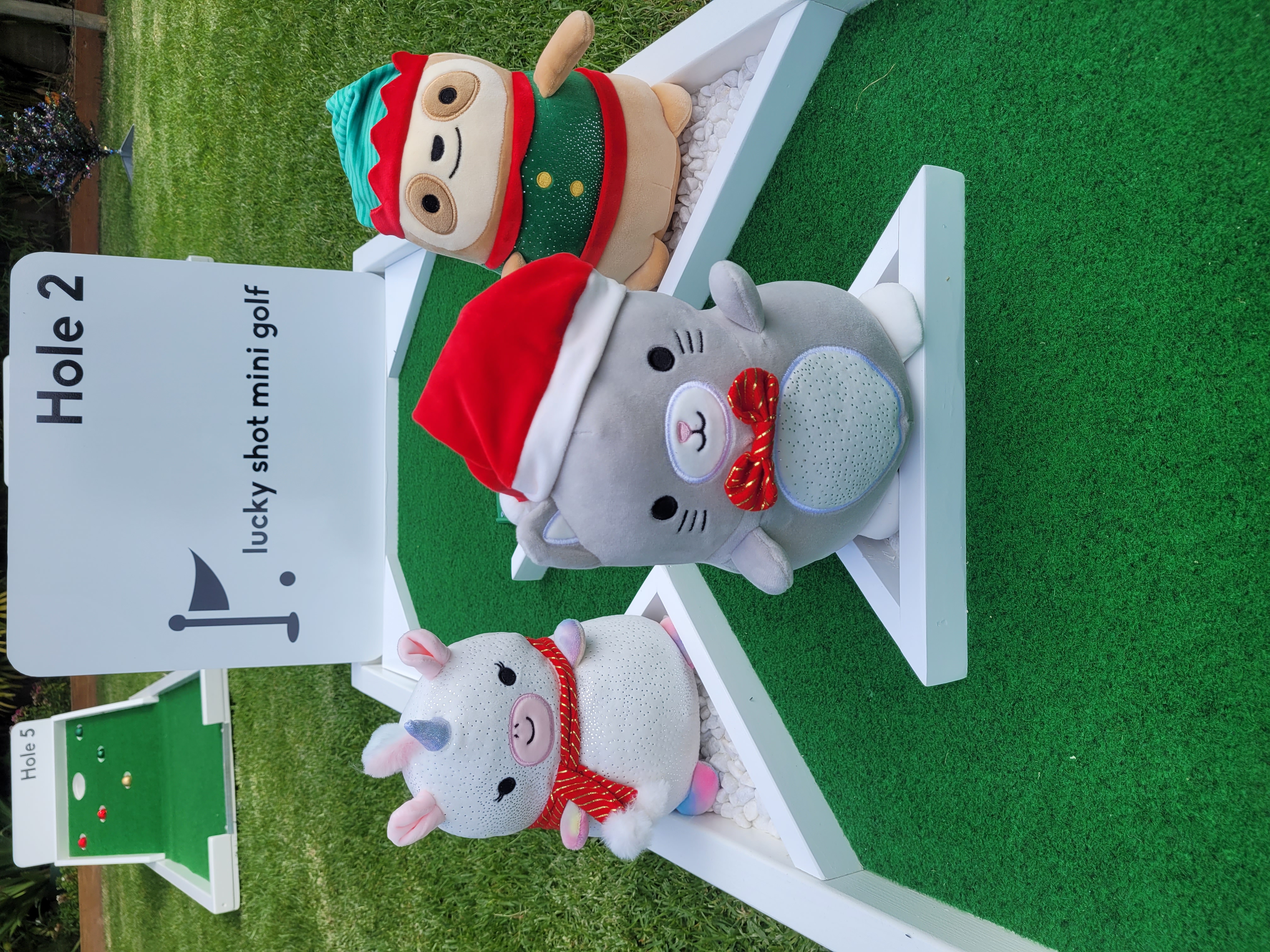 Christmas themed mini golf props — festive plush toy decorations on the course