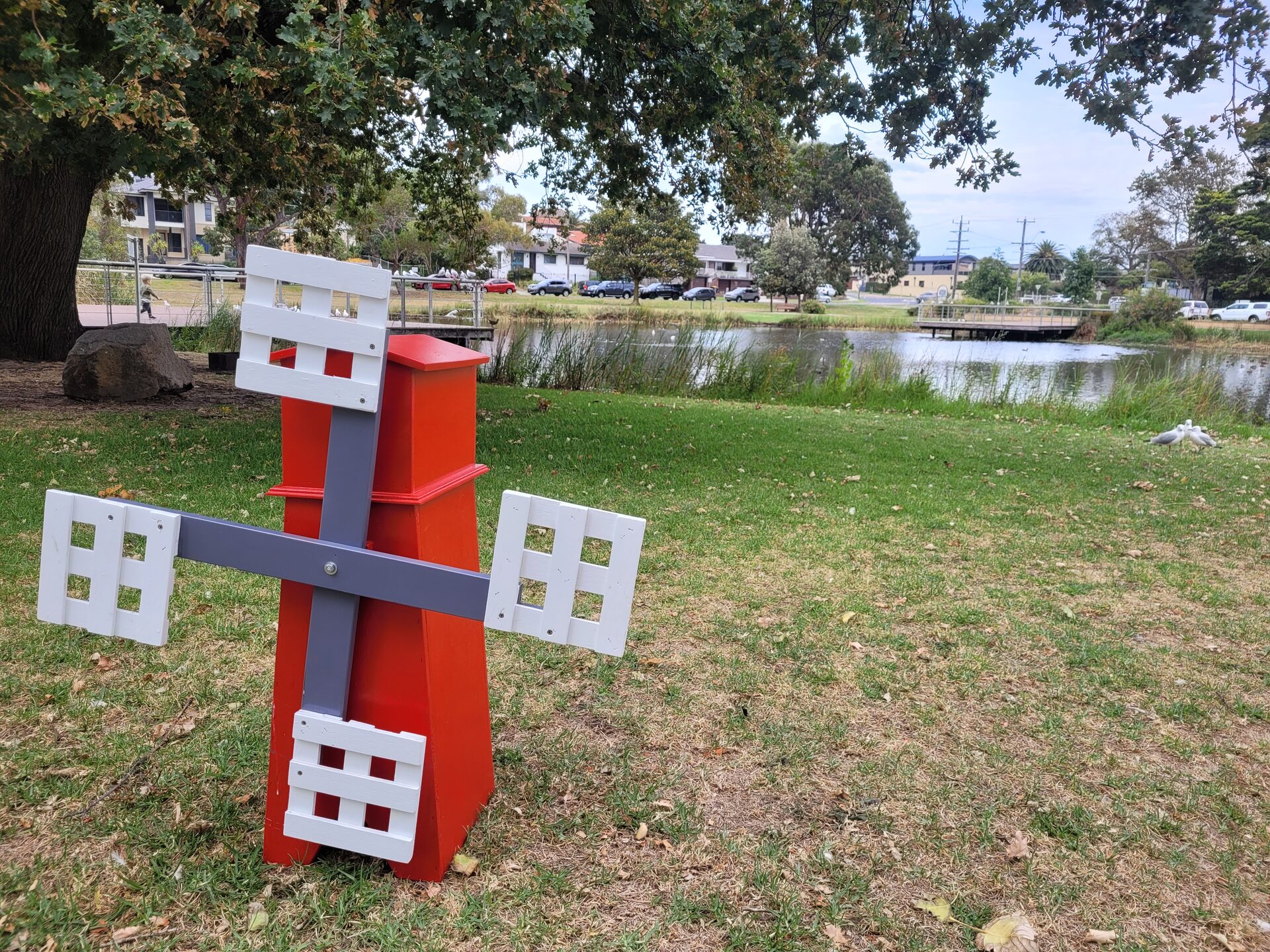 Lucky Shot Mini Golf red windmill obstacle set up on parkland by a pond in suburban Melbourne
