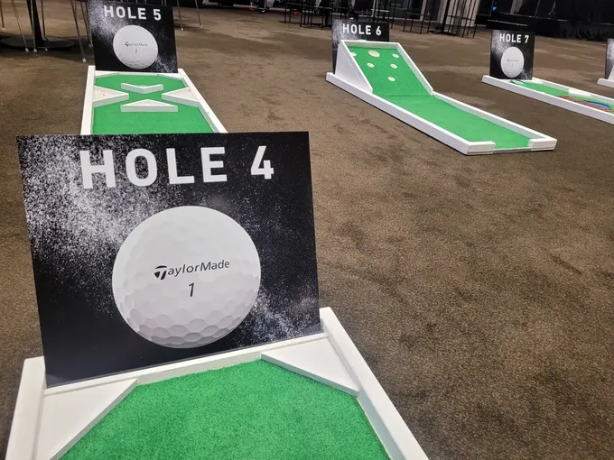 A TaylorMade branded hole marker on the Lucky Shot mini golf course